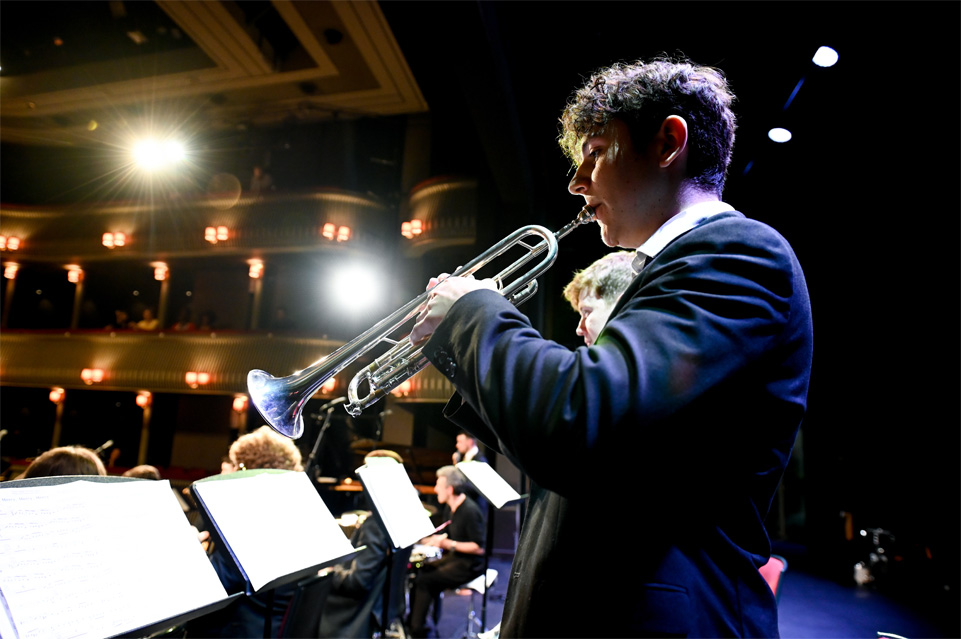 Male student performing on the trumpet in a jazz performance, with other brass performers, at the RCM's percussion festival 2023.